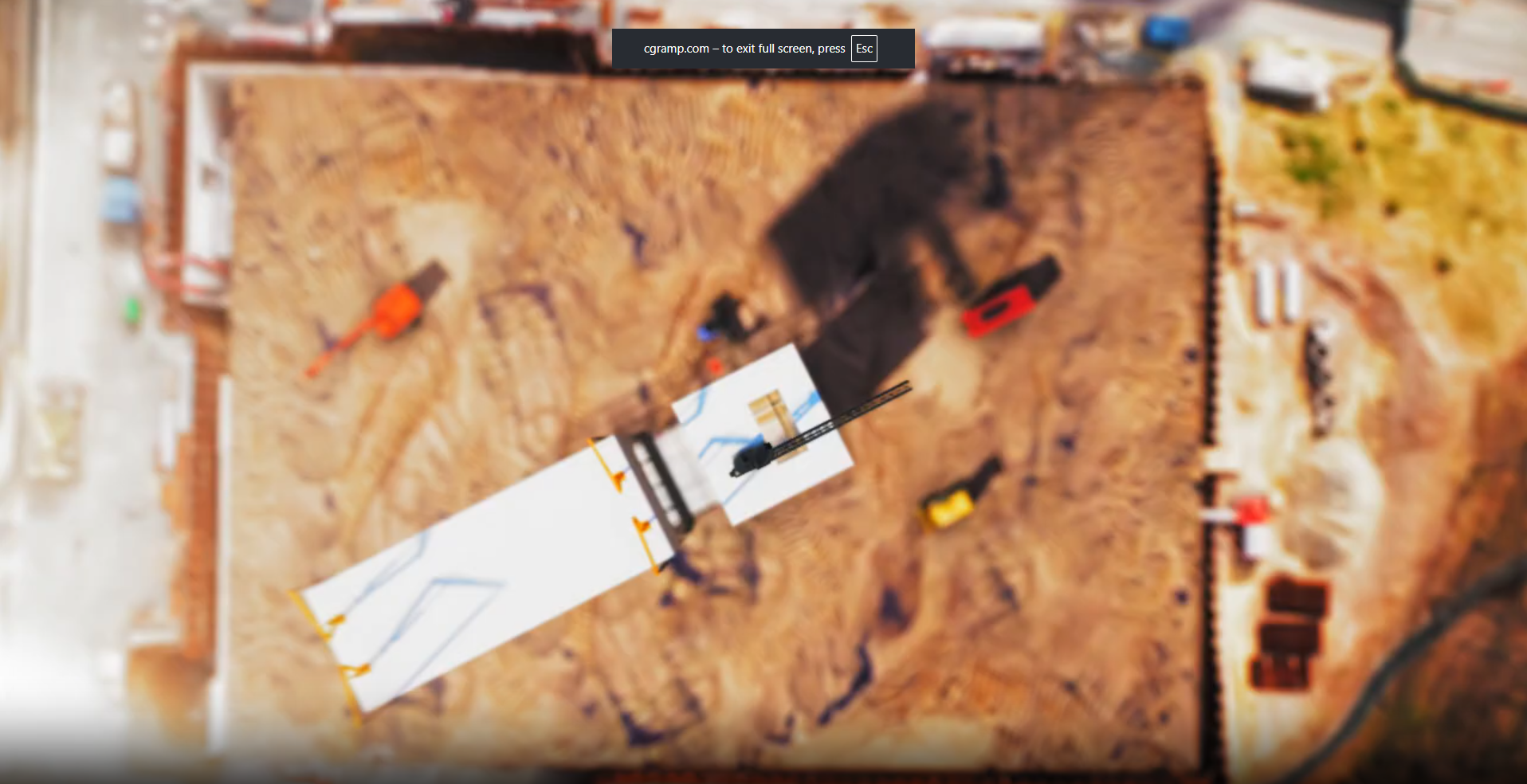 Aerial view of a construction site with machinery, equipment, and building foundation seen from above with blurred effect